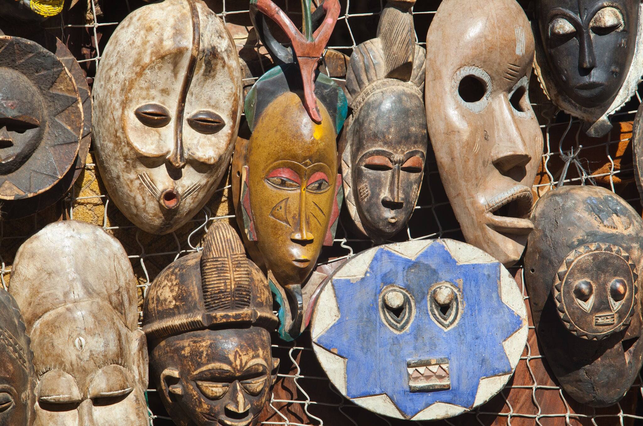 Traditional african masks hanging for sell in a market stall