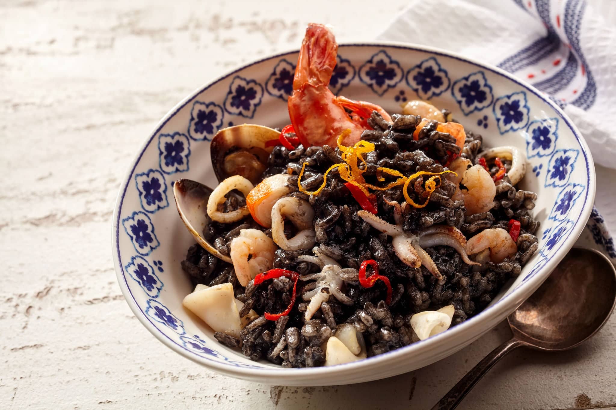 Single serving of seafood risotto named nero specialty dish with shrimp and scallops smothered in ink from squid