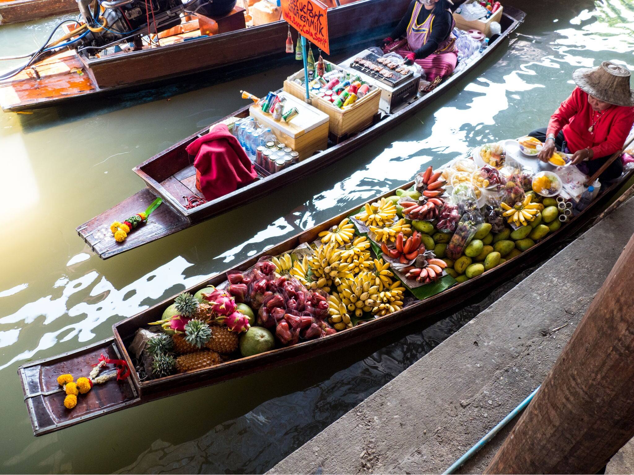 Damnoen saduak floating market.Thai market-red, yellow fruits.