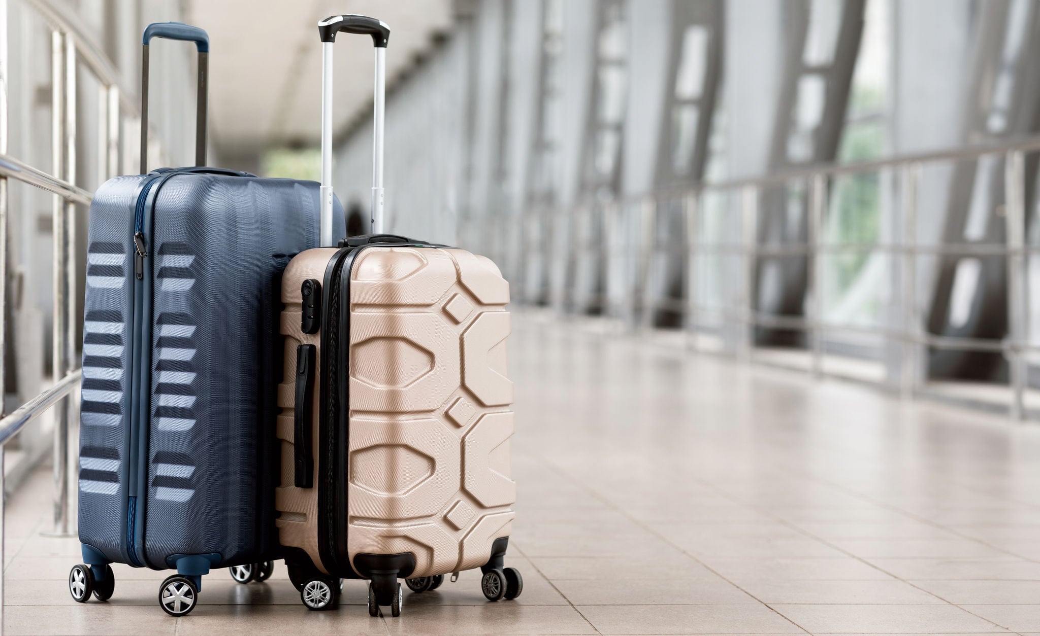 Travel Fashion. Closeup Shot Of Two Plastic Suitcases Standing At Empty Airport Corridor, Stylish Luggage Bags Waiting At Terminal Hall, Banner For Air Travelling And Vacation Booking Concept