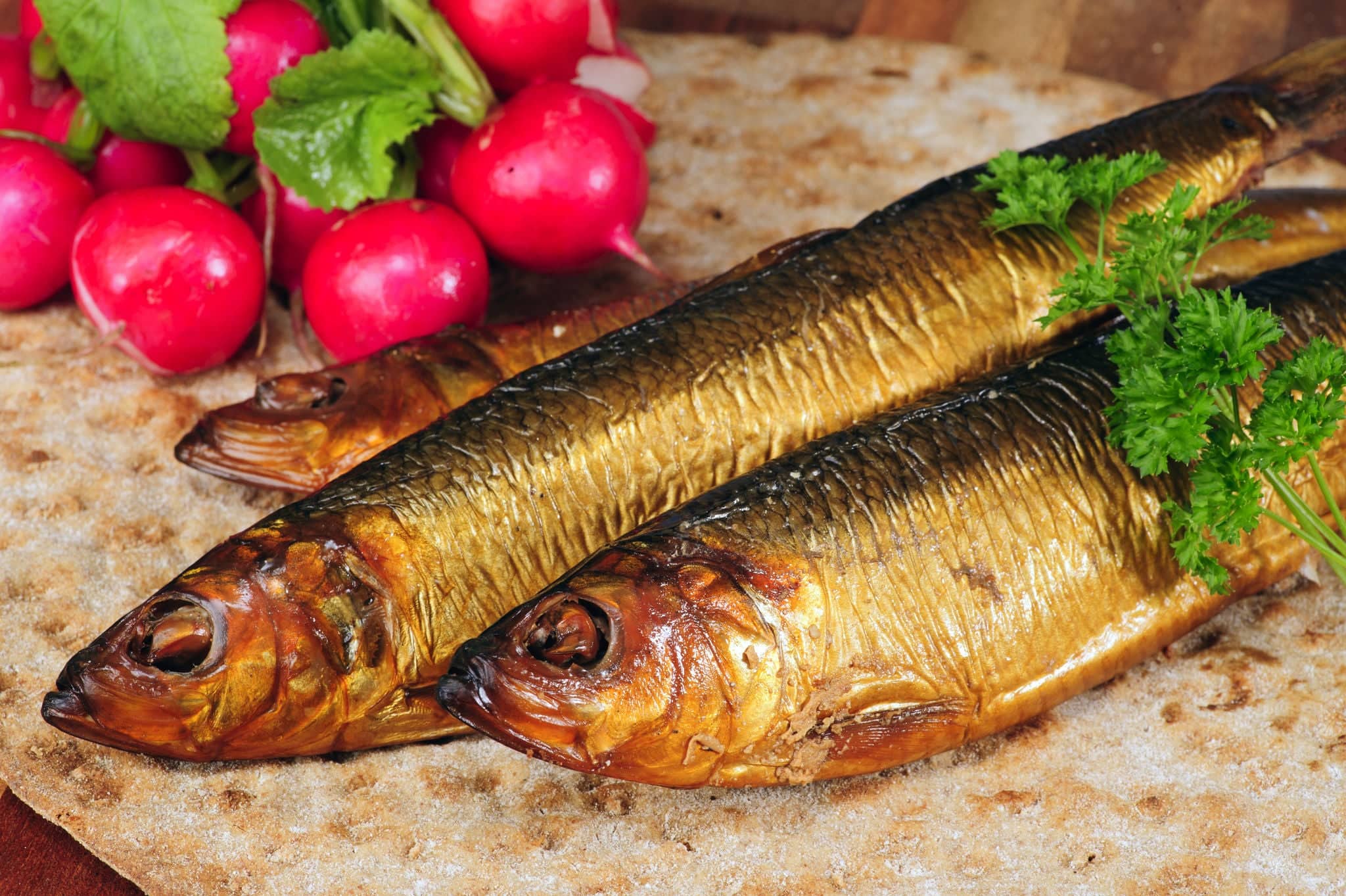 Smoked herring on crispbread, decorated with radishes and parsley.