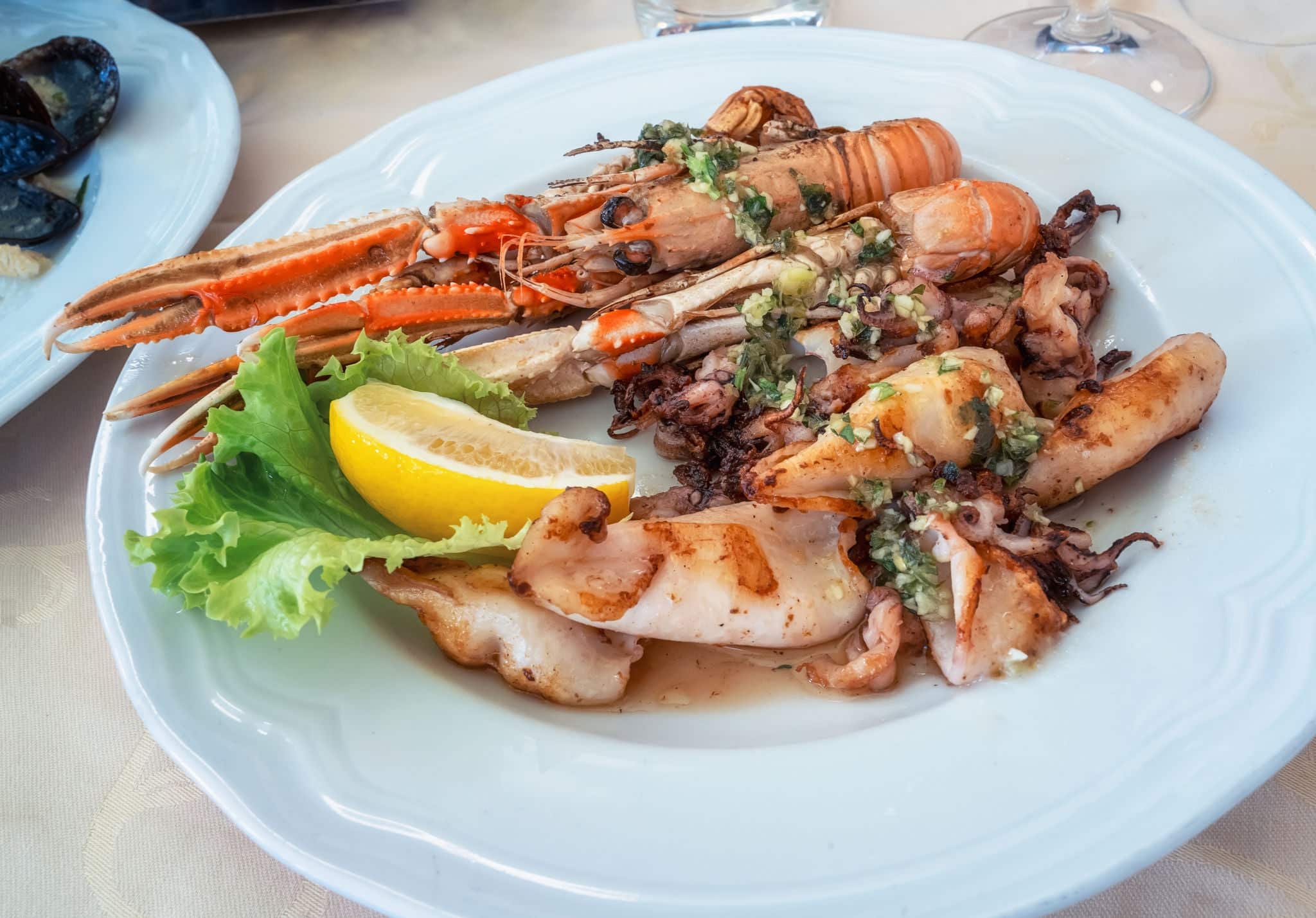 A delicious Mediterranean dish of grilled lobster and squids, served on a platter in a small restaurant on the main promenade of Piran, Slovenia