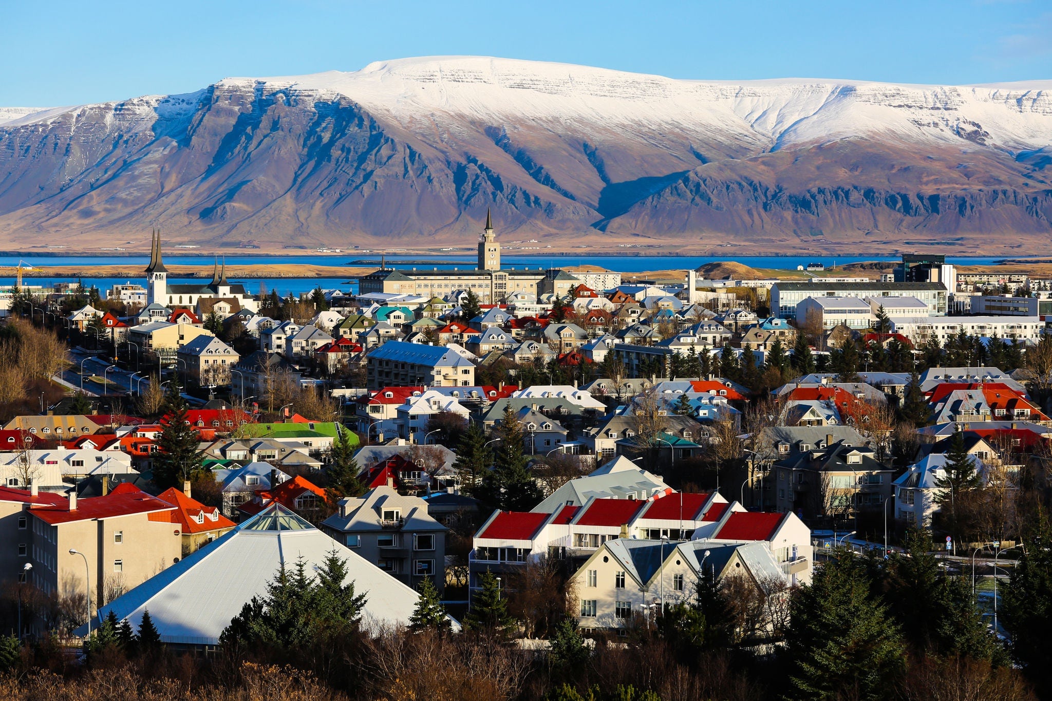 Aerial view of Reykjavik, Iceland with snow capped mountains in the background