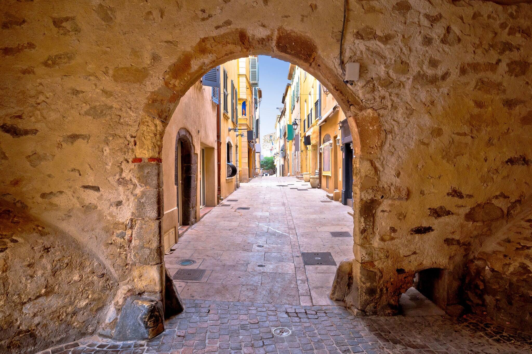 Saint Tropez historic town gate and colorful street view, tourist destination of French riviera