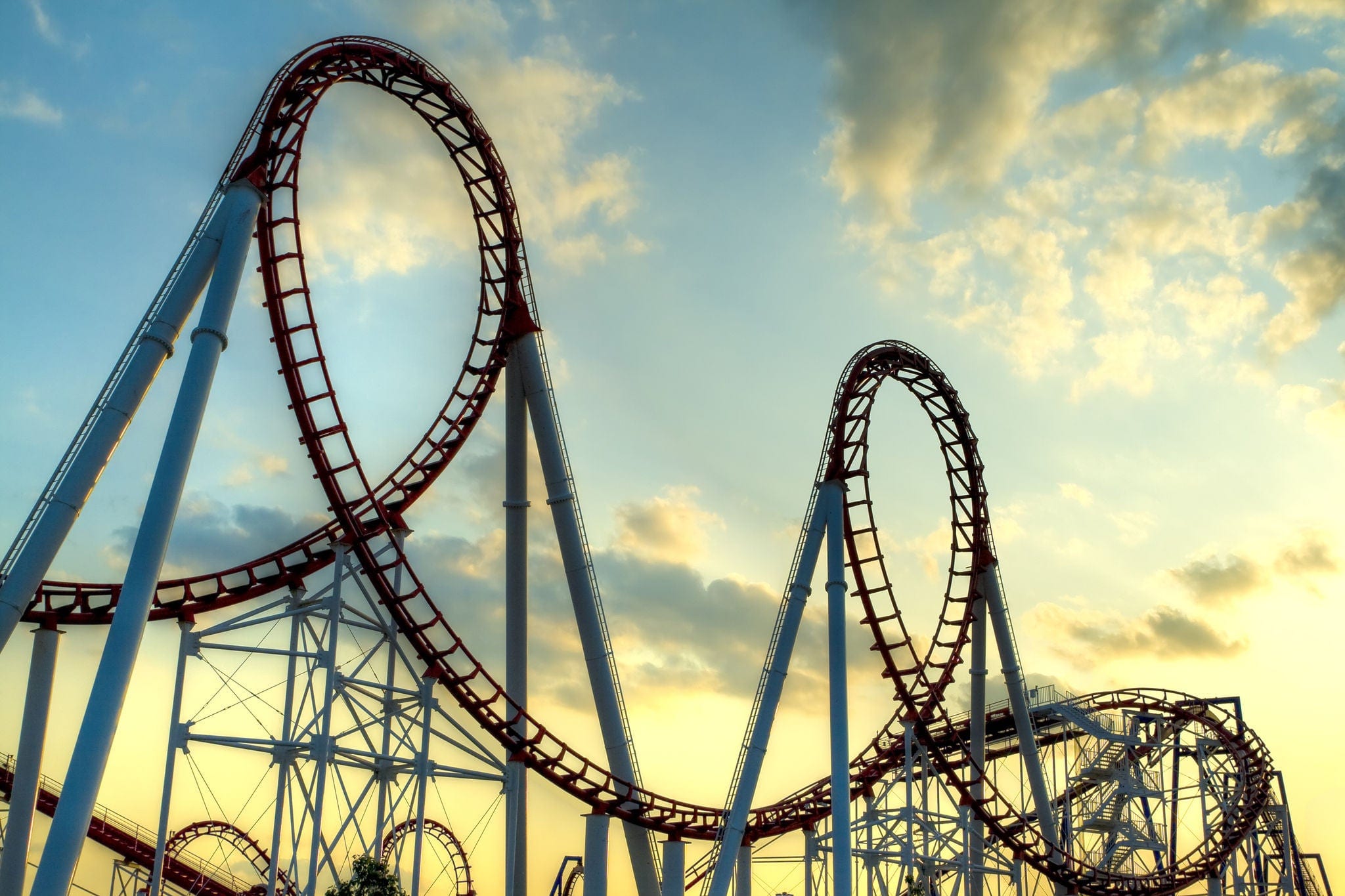 Panoramic shot of a roller coaster's loop at sunset.