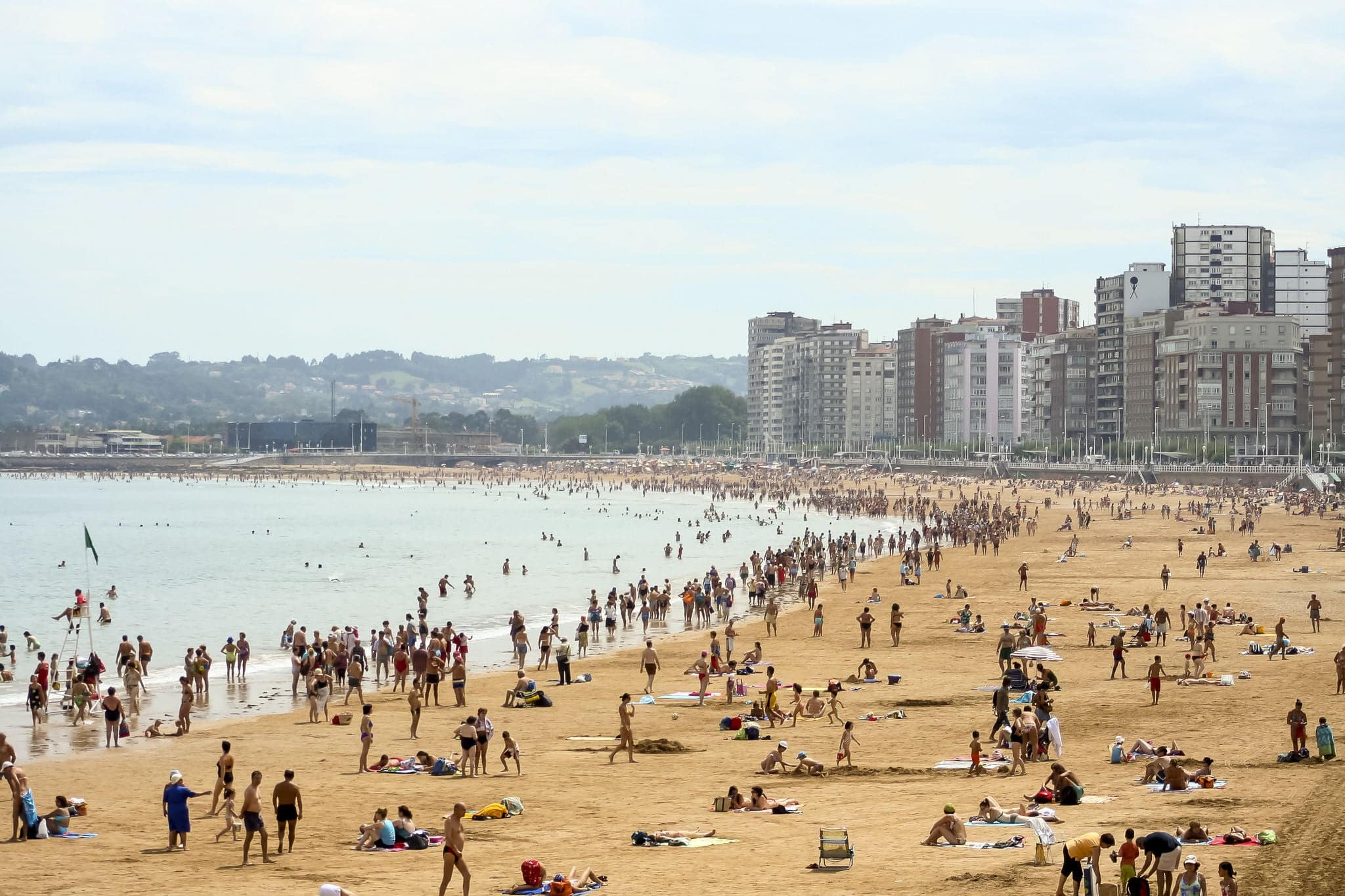 landscape of the San Lorenzo beach in Gijon, Asturias, Spain. umbrellas folded in sand