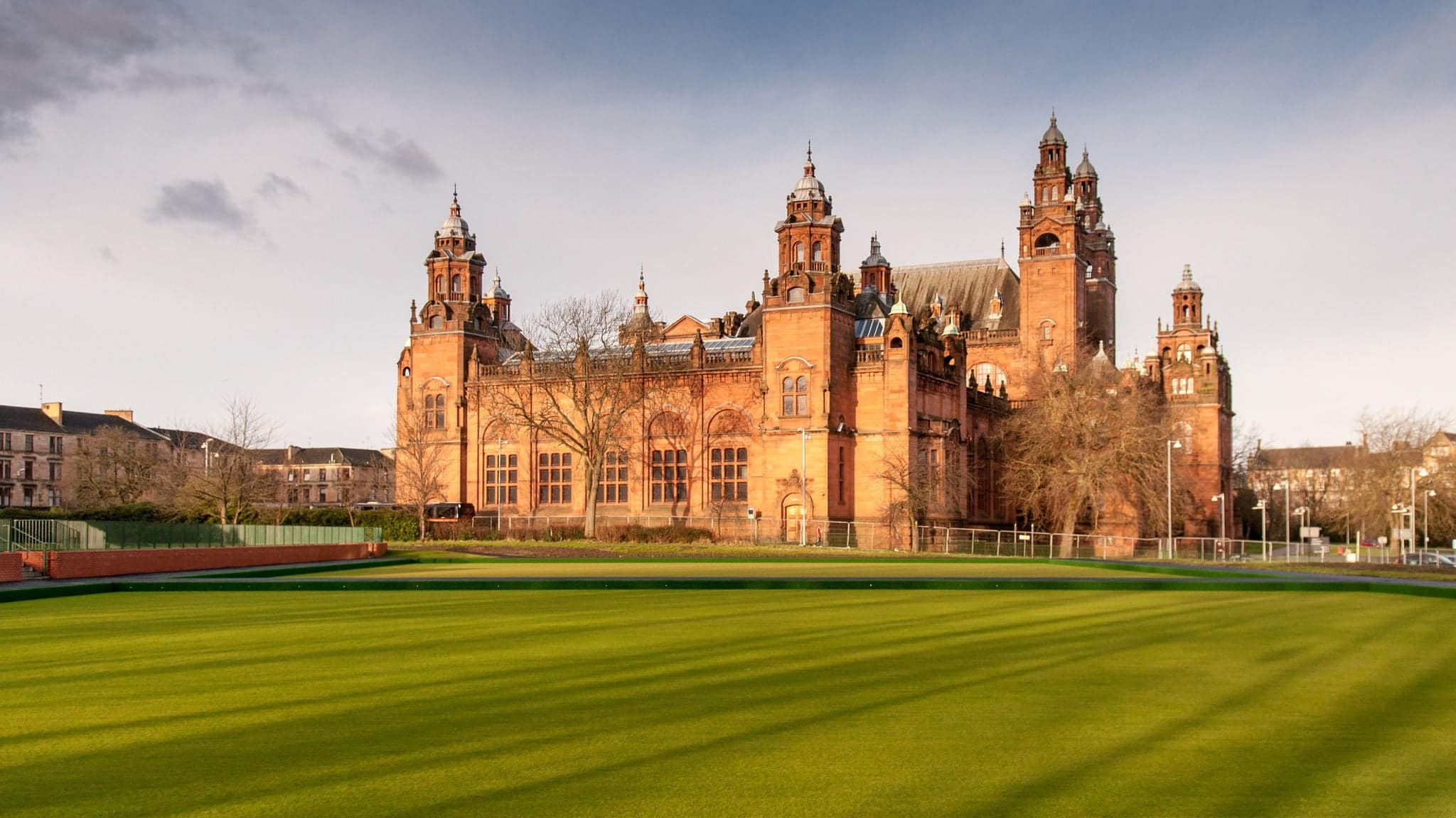 Glasgow, Scotland, UK - January 19, 2012: The grand Victorian Kelvingrove Museum and Art Gallery stands illuminated by evening sun amongst lawns in Glasgow's West End.