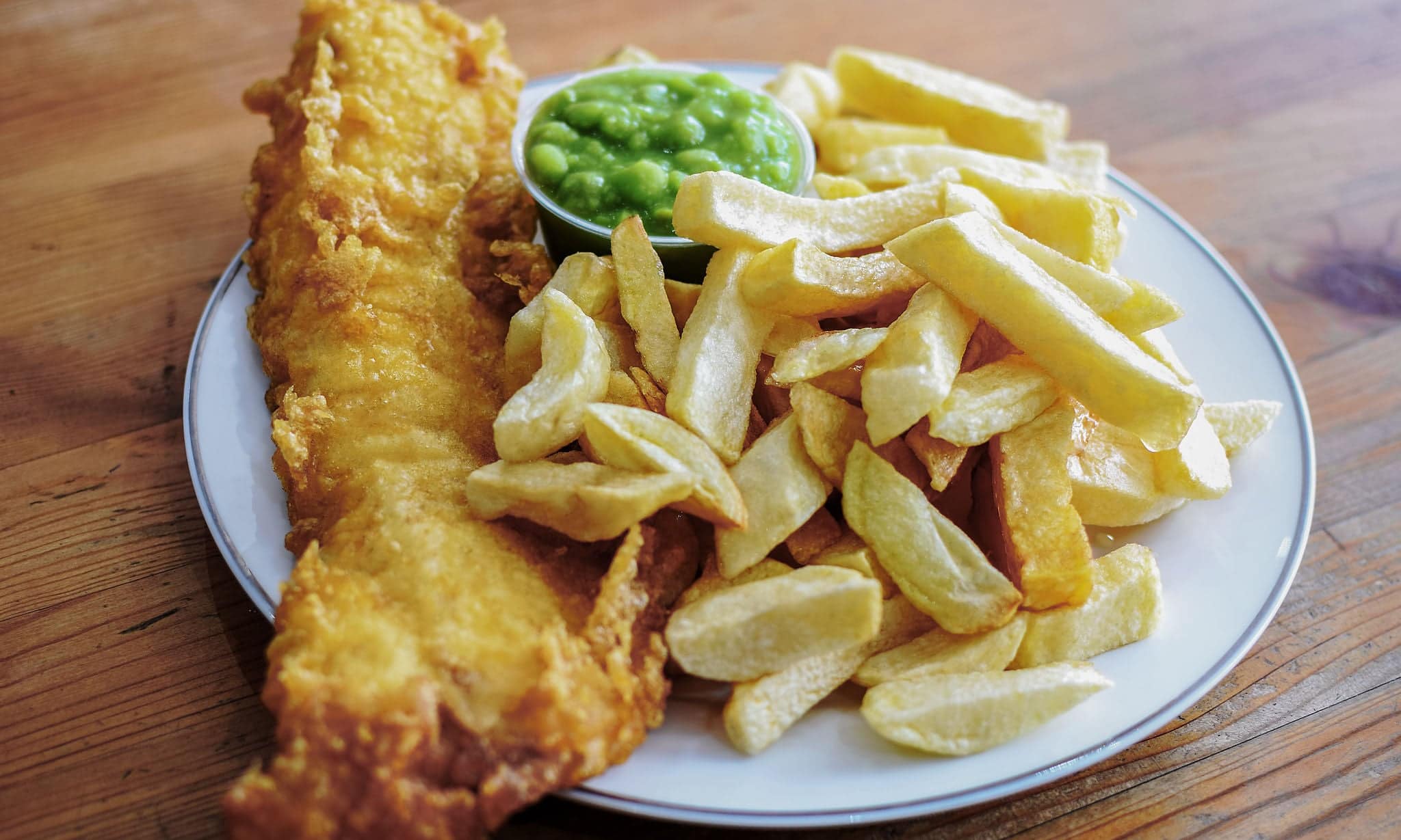 Delicious deep fried battered Cod Fish with Chips in a Fish and Chips restaurant in Greater London