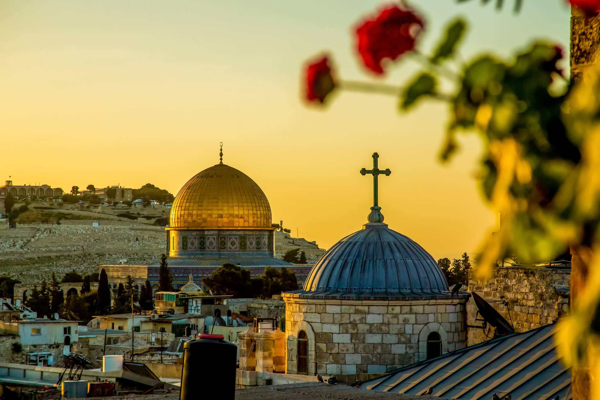 The dome of a Christian church and the dome of the rock in the setting sun