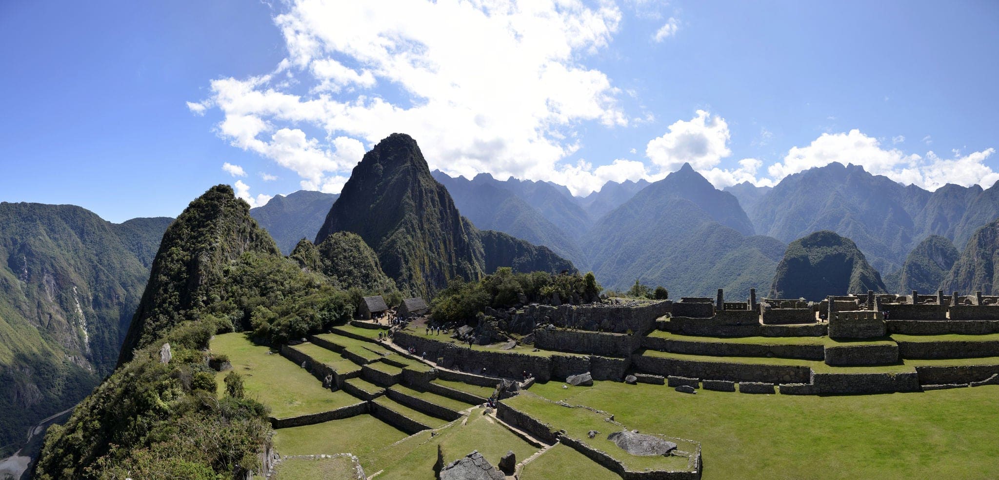Panorama of Terraces Machu Pichu with Huayna Picchu in Peru, rainforest jungle and mountains with blue sky in the background