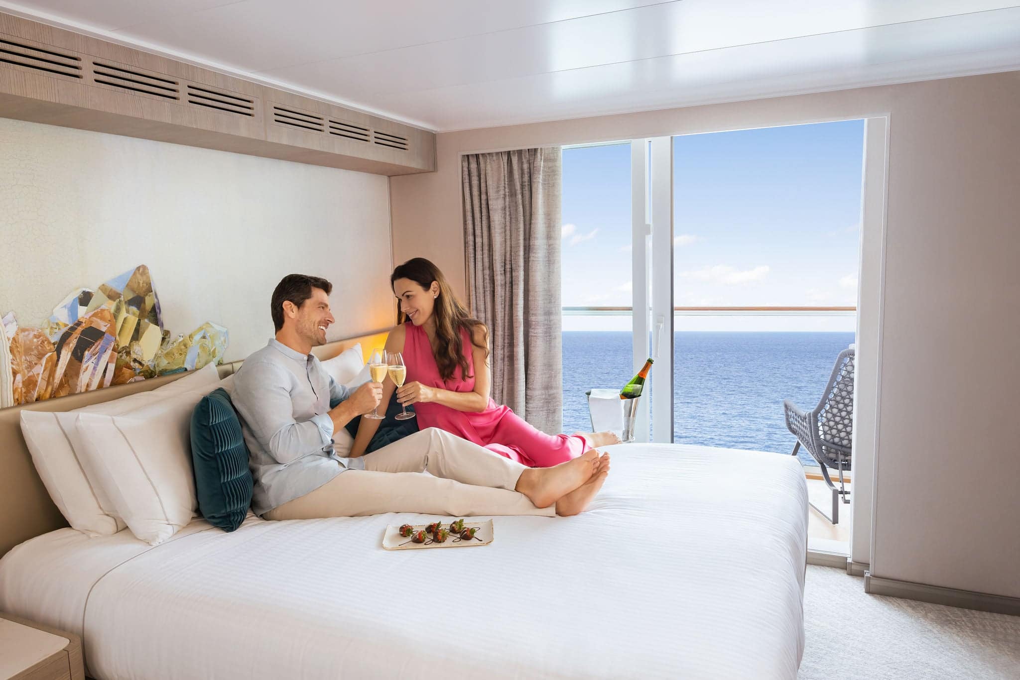 A couple relaxing in a Prima balcony stateroom
