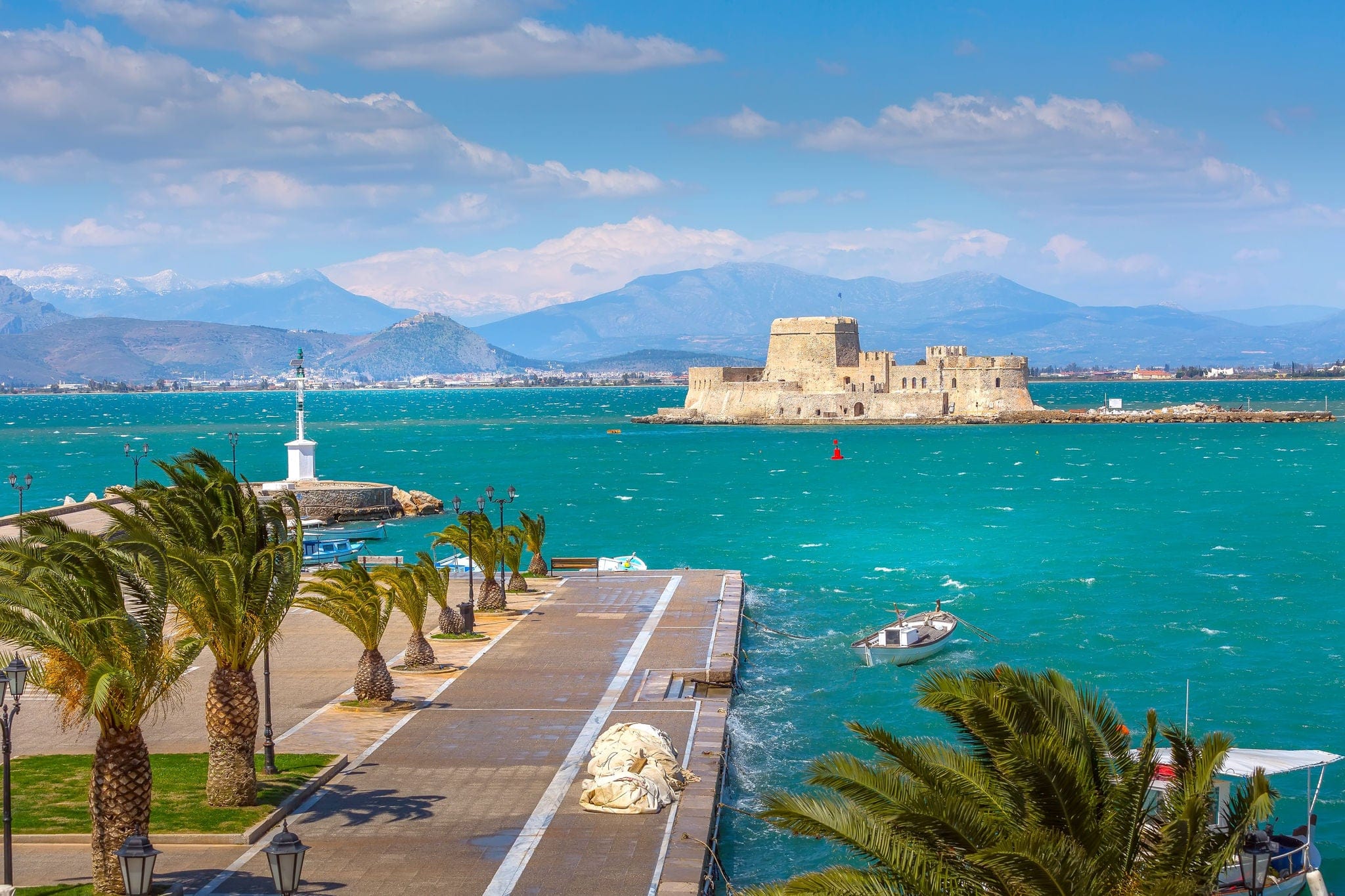 Promenade with palm trees and Bourtzi fortress in the sea in Nafplio or Nafplion, Greece, Peloponnese