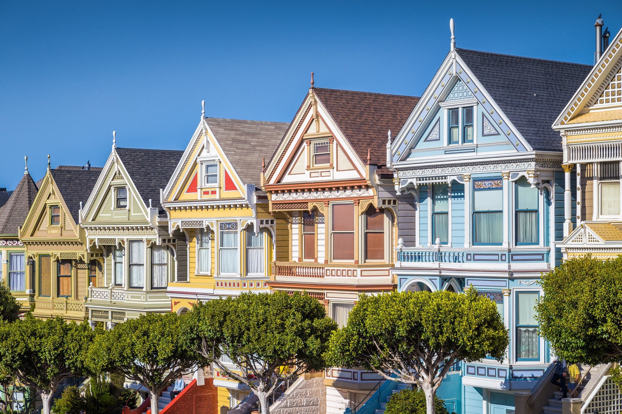 Classic postcard view of famous Painted Ladies, a row of colorful Victorian houses located near scenic Alamo Square, on a beautiful sunny day with blue sky in summer, San Francisco, California, USA