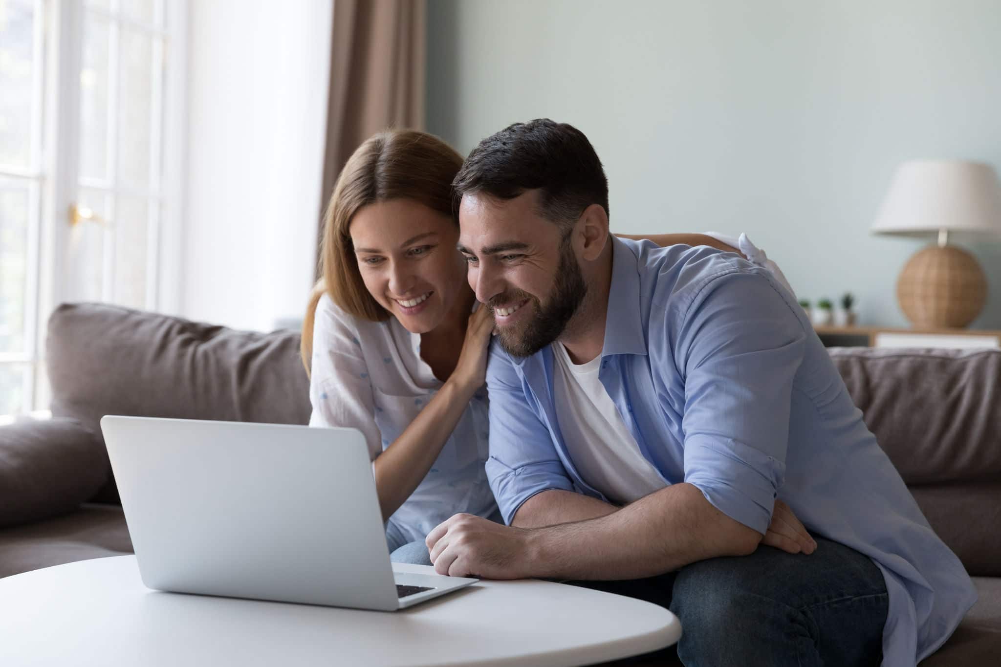 Couple staring at laptop screen smile enjoy good news, reading received notification feel satisfied spend time using modern device. Wireless technology, marketplace on-line, e-shopping at home