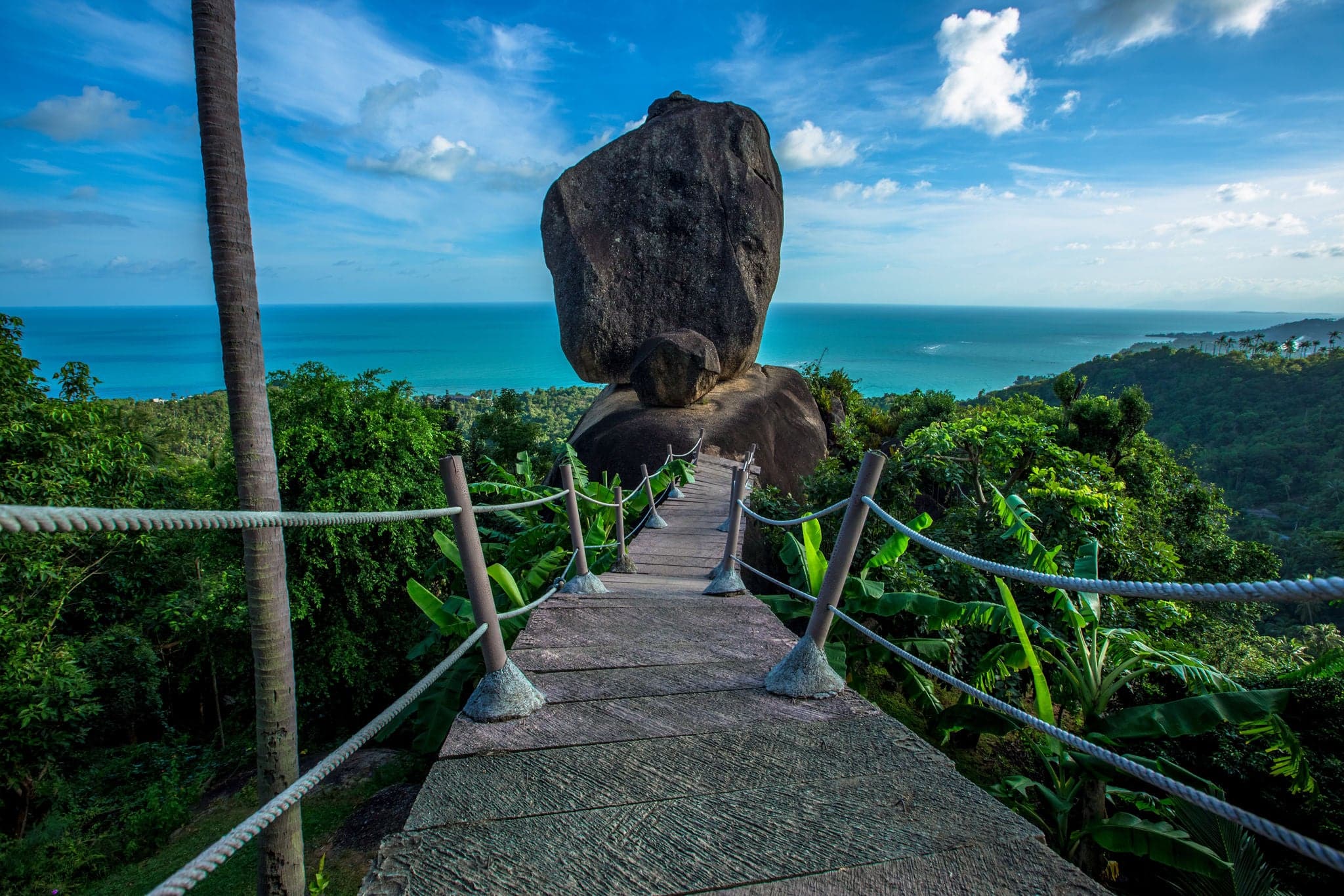 Fondo de luz natural nocturna en montañas altas con vista al mar, cocoteros, villas en la ladera y grandes rocas en Koh Samui