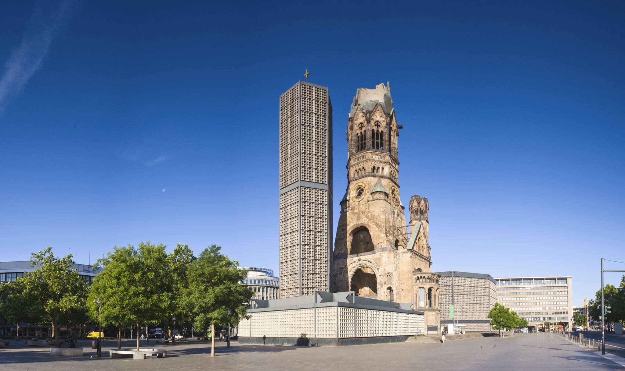 Kaiser-Wilhelm-Kirche, broken spire and modern bell tower overlook the busy Breitscheidplatz as symbols of the city's regeneration.