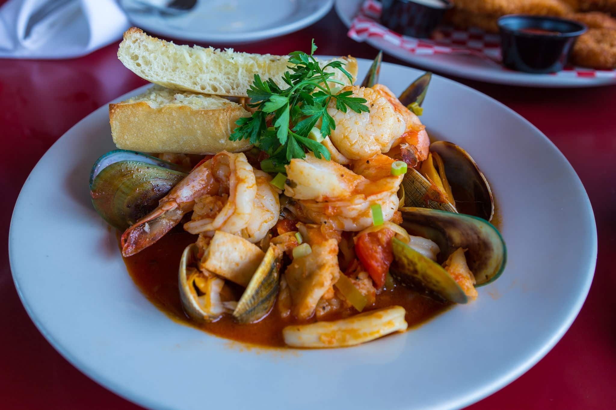 Assorted delicious seafood on the plate. Shrimps, mussels and squid decorated with parsley. Monterey, California, USA.