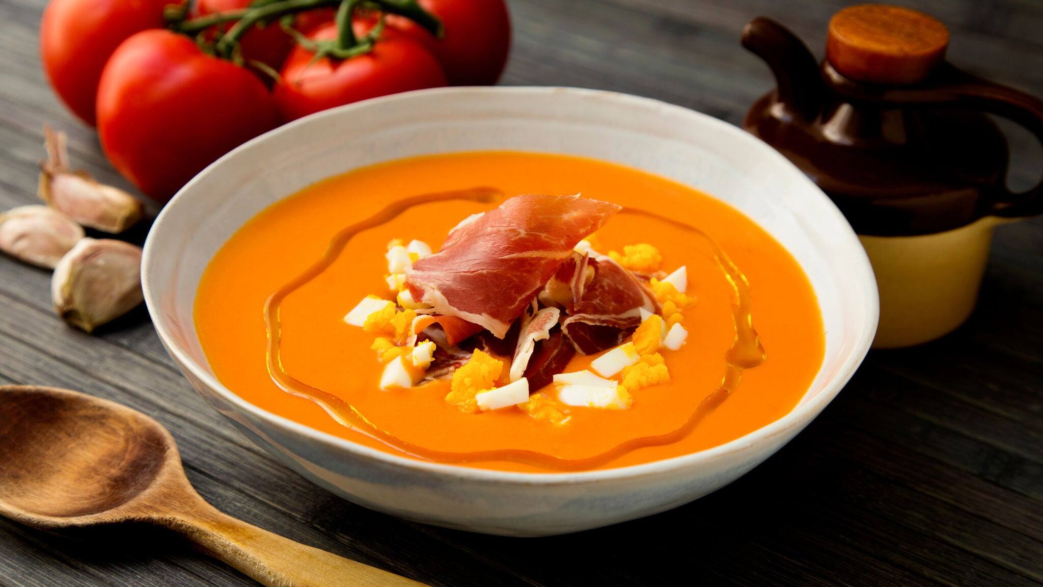 Traditional spanish salmorejo. Cold tomato soup served with egg and iberico jam.