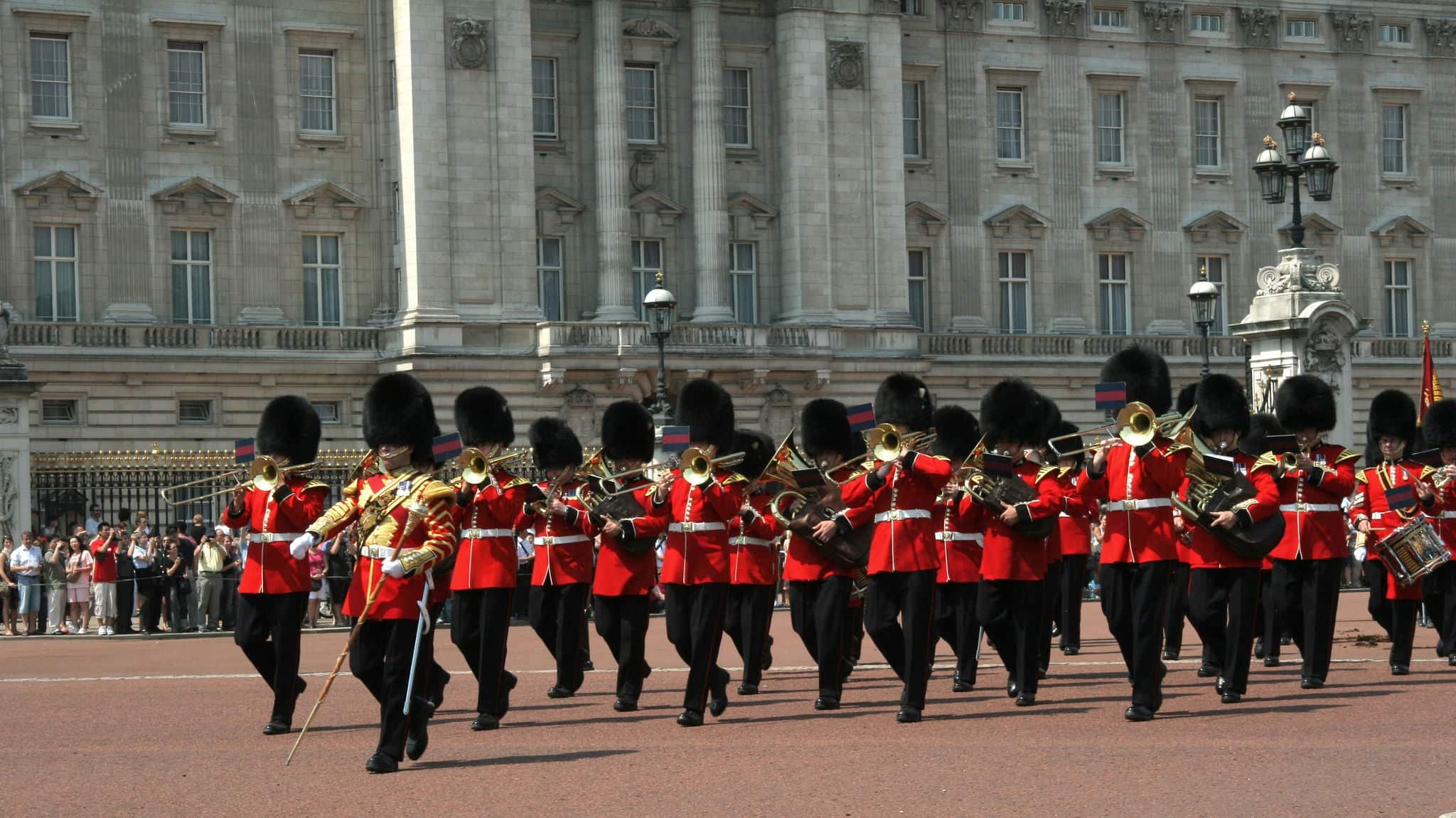 a guards band marching in front of buckingham palace