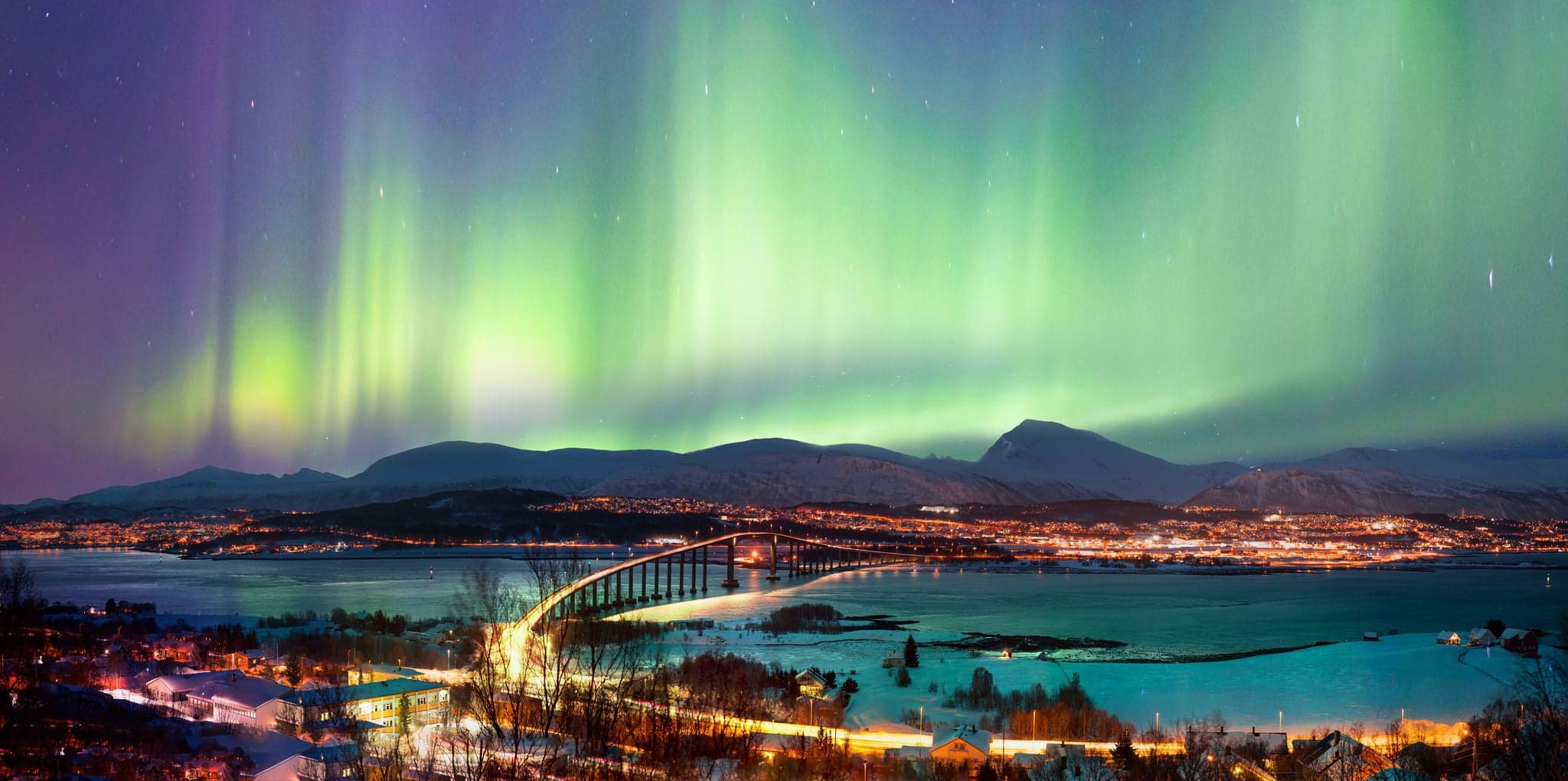 Aurora borealis or Northern lights in the sky over Tromso with Sandnessundet Bridge - Tromso, Norway