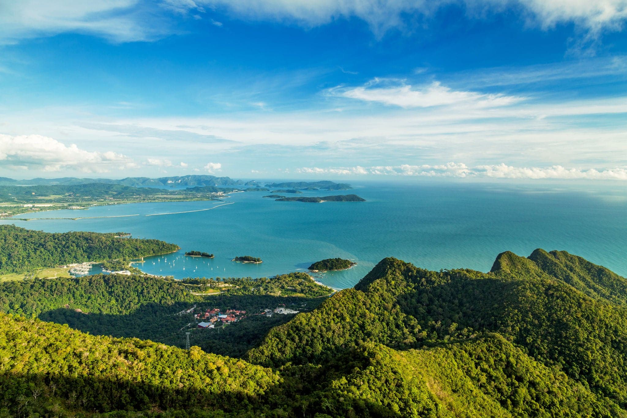 View of tropical island Langkawi in Malaysia, covered with tropical forests. Aerial view on the bay, marina and archipelago of smaller islands in Andaman sea.