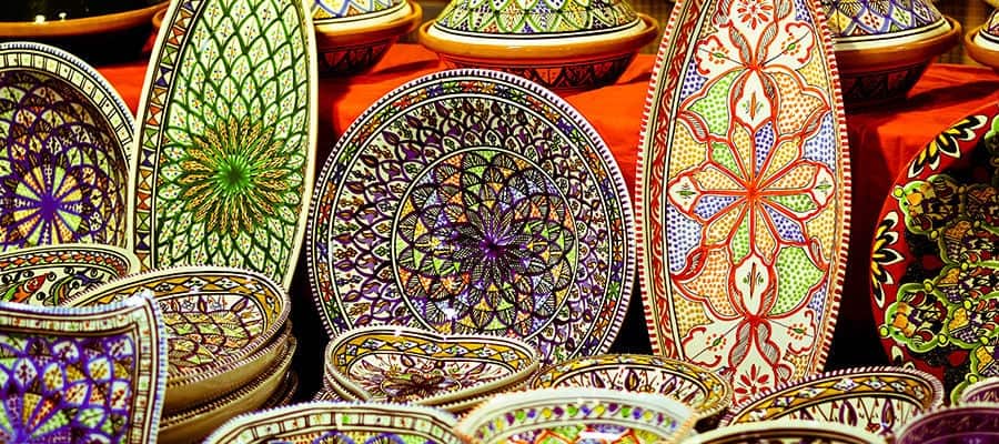 Artisan decorated plates displayed on market table in Port Said, Egypt.