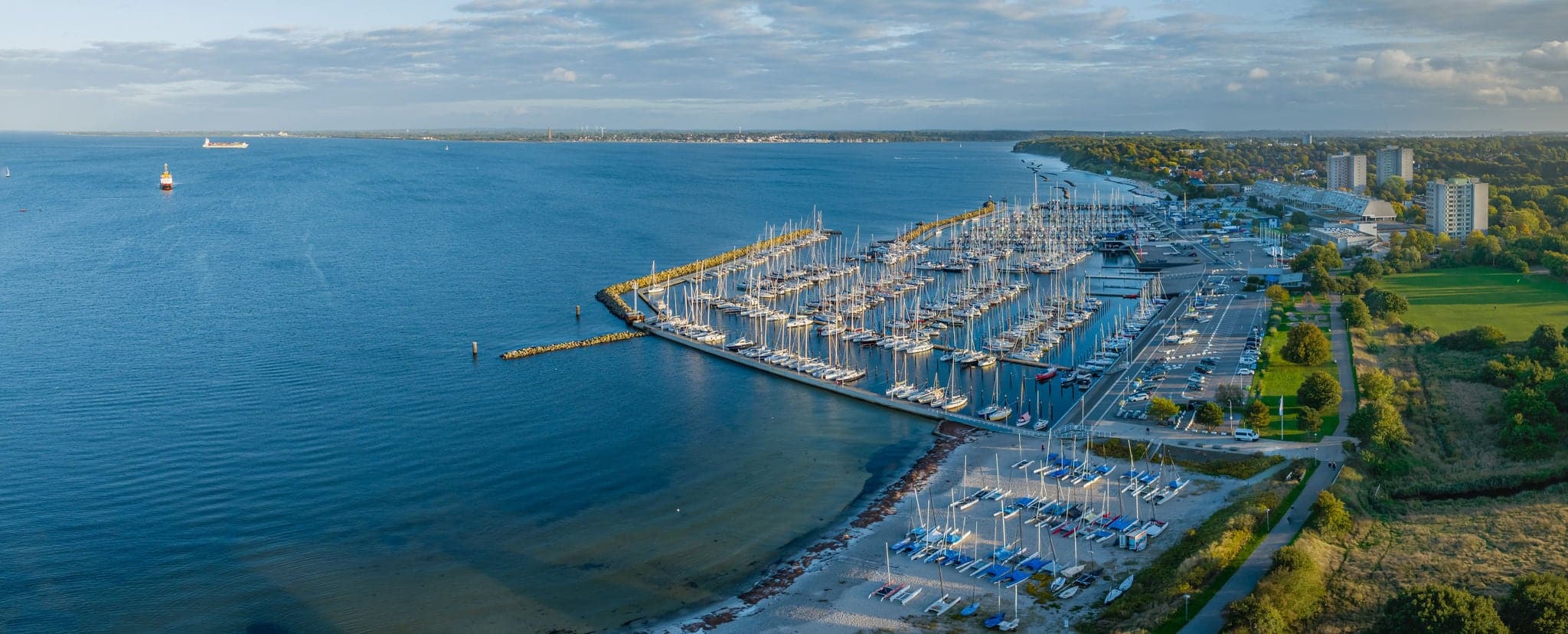 Aerial view of marina Schilksee with sailing boats docked at the pier. Aerial view of popular sailing vacation destination Schilksee with Olympic center with marina on the Baltic Sea.