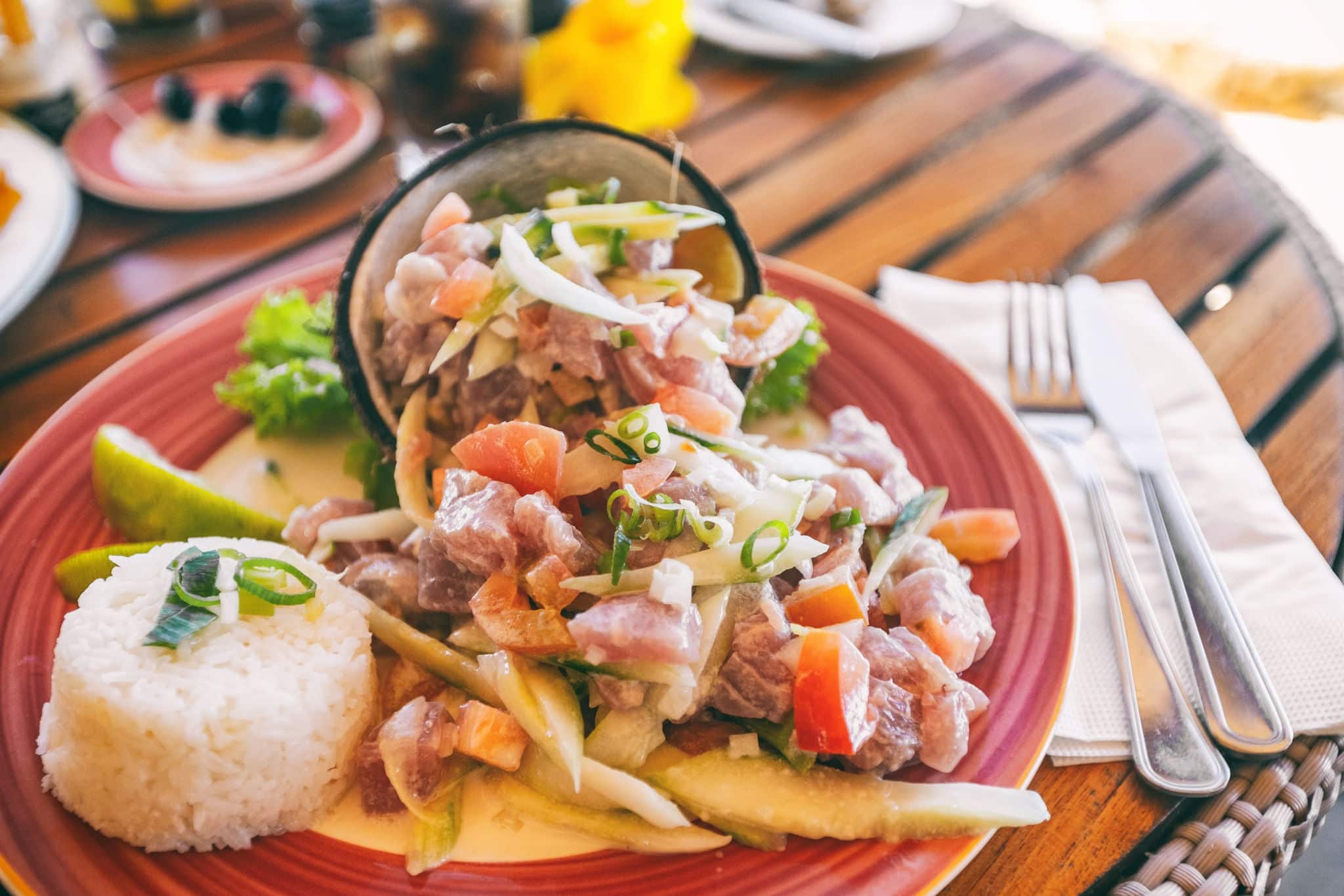 Tahiti food National dish local typical cuisine - Tahitian Raw Fish salad called Poisson Cru in French Polynesia. Top view of hotel restaurant meal in Bora Bora.