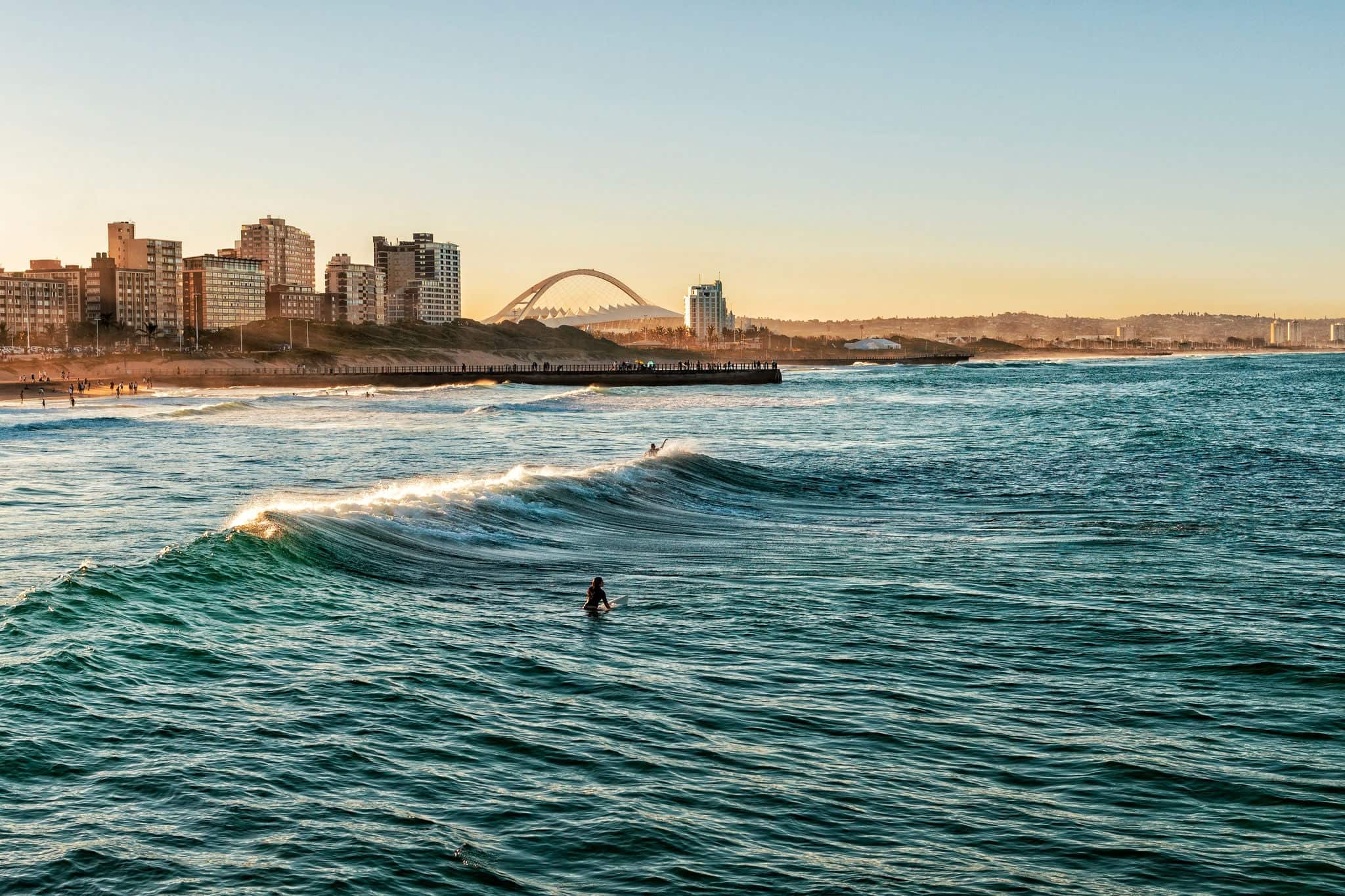 Surfers Enjoying the Waves During Sunset