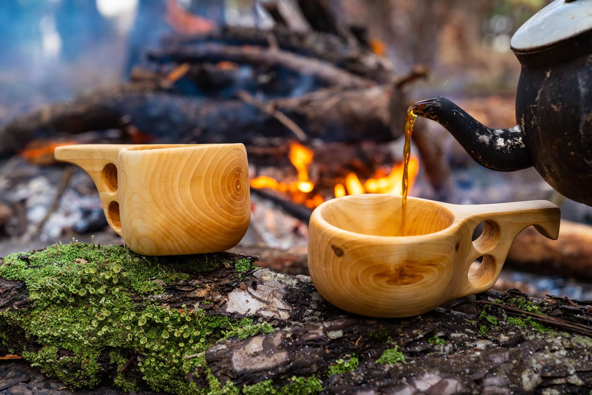 wooden finnish mug, called Kuksa on the stump, with camp fire