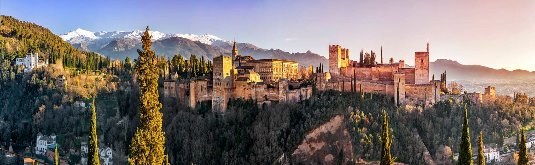 Palace and fortress complex Alhambra with Comares Tower, Palacios Nazaries and Palace of Charles V during sunset in Granada, Andalusia, Spain.