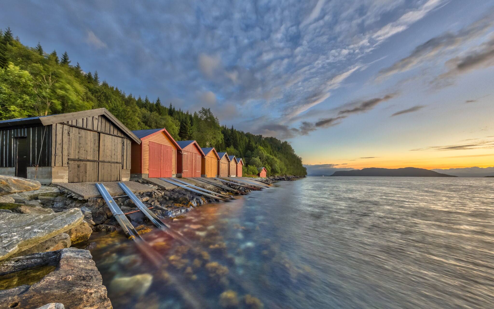 Sunset over Norwegian fjord with Colorful Boathouses near Rodven in More og Romsdal province at sunset