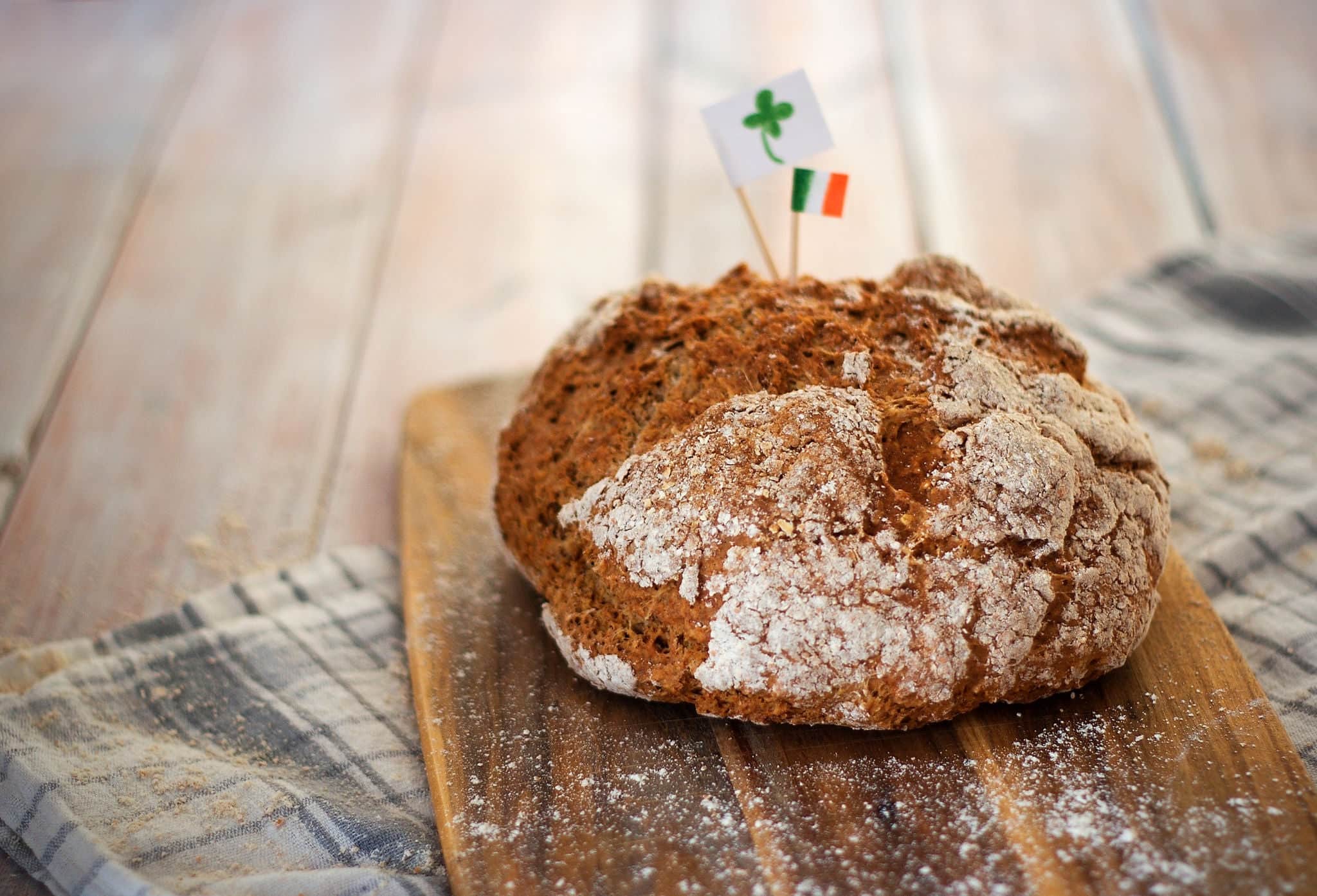 Homemade whole wheat irish soda bread decorated by irish flag and cloverleaf