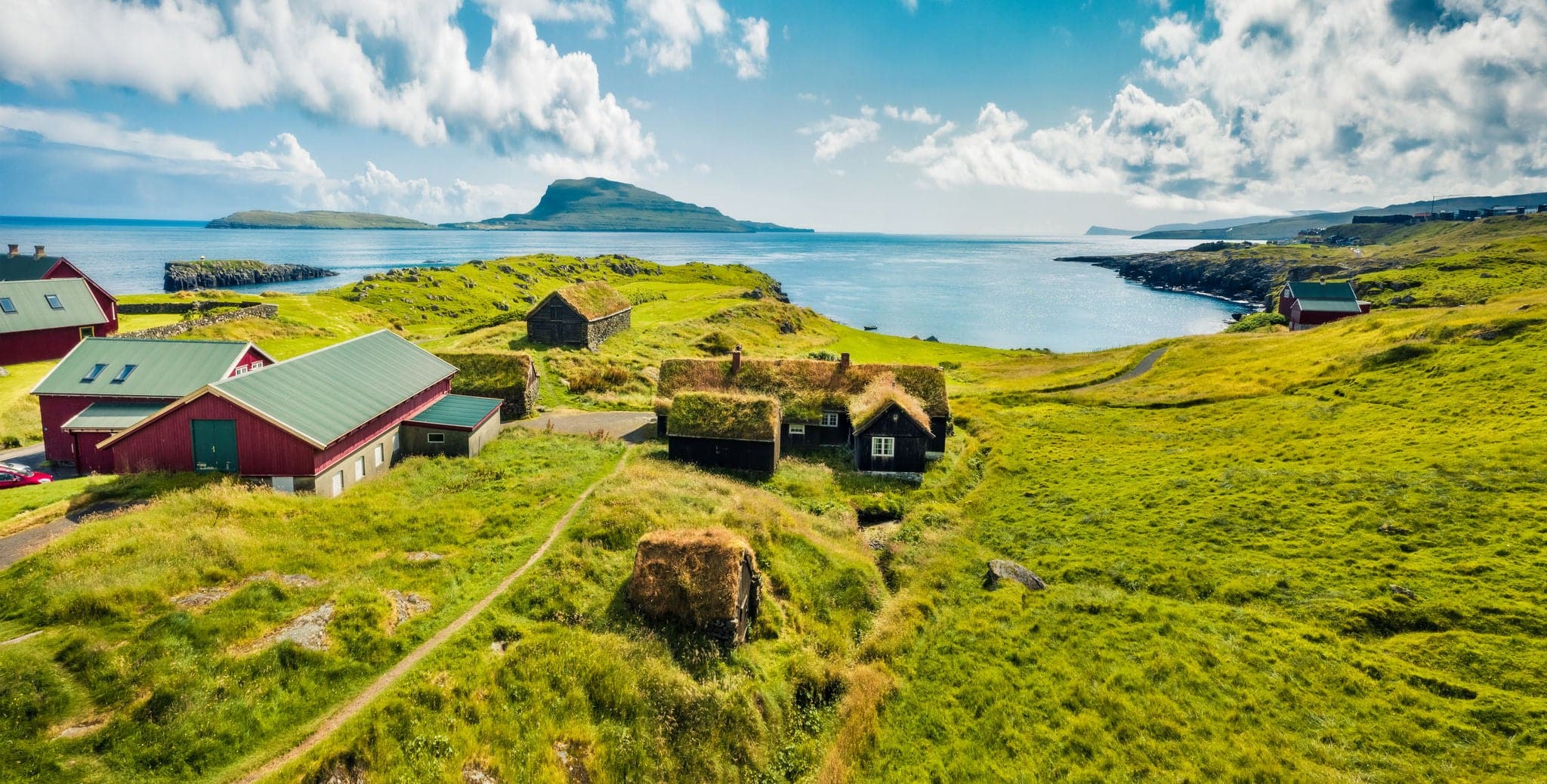 Panoramic morning view of typical turf-top houses. Picturesque summer scene of outskirts of Torshavn city, capital of Faroe Islands, Kingdom of Denmark, Europe. Traveling concept background.