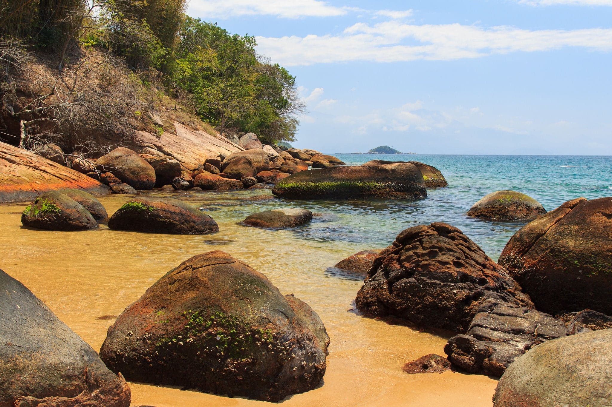 Beach stones transparent sea blue sky island Ilha Grande, Rio de Janeiro, Brazil