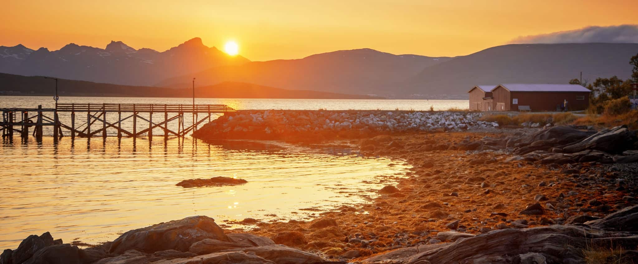 Bright beautiful orange sunset on the Norwegian Sea, Tromso Norway. Midnight sun