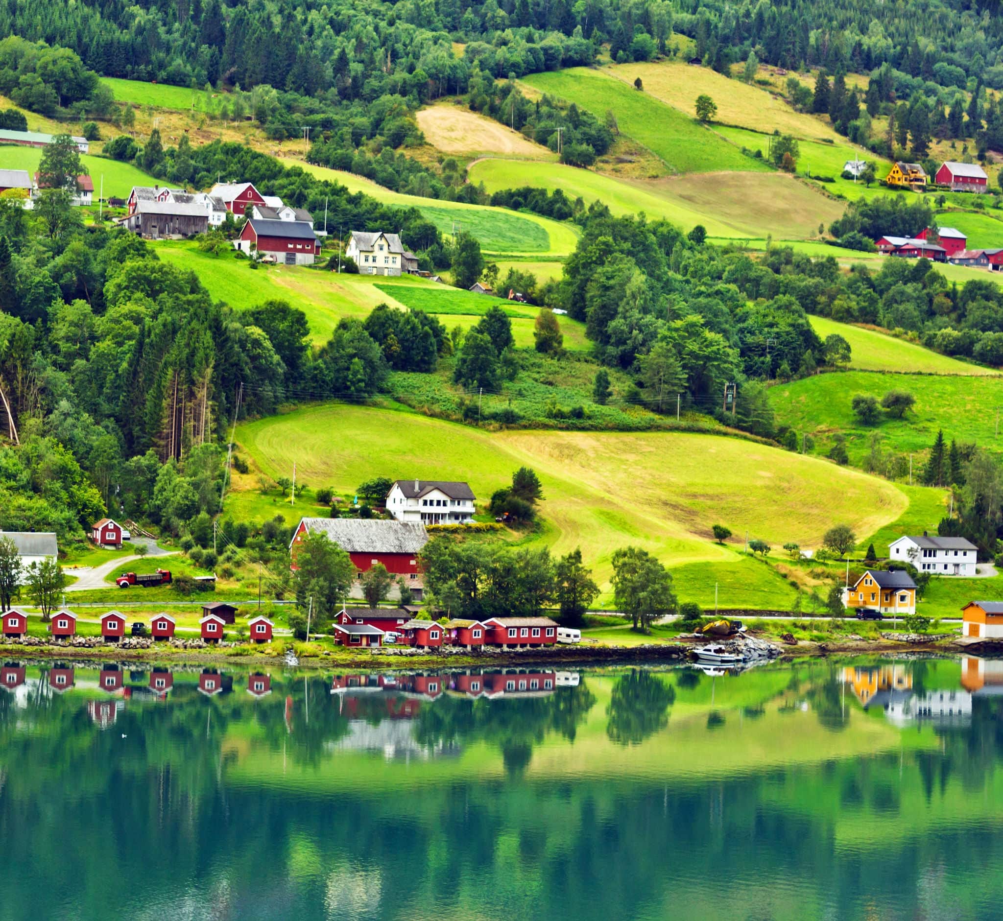 Small town and cruise port Olden in Norwegian fjords. Tourist camping on the beach.