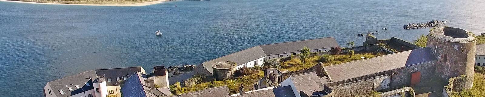 Aerial view of coast of Greencastle overlooking water.