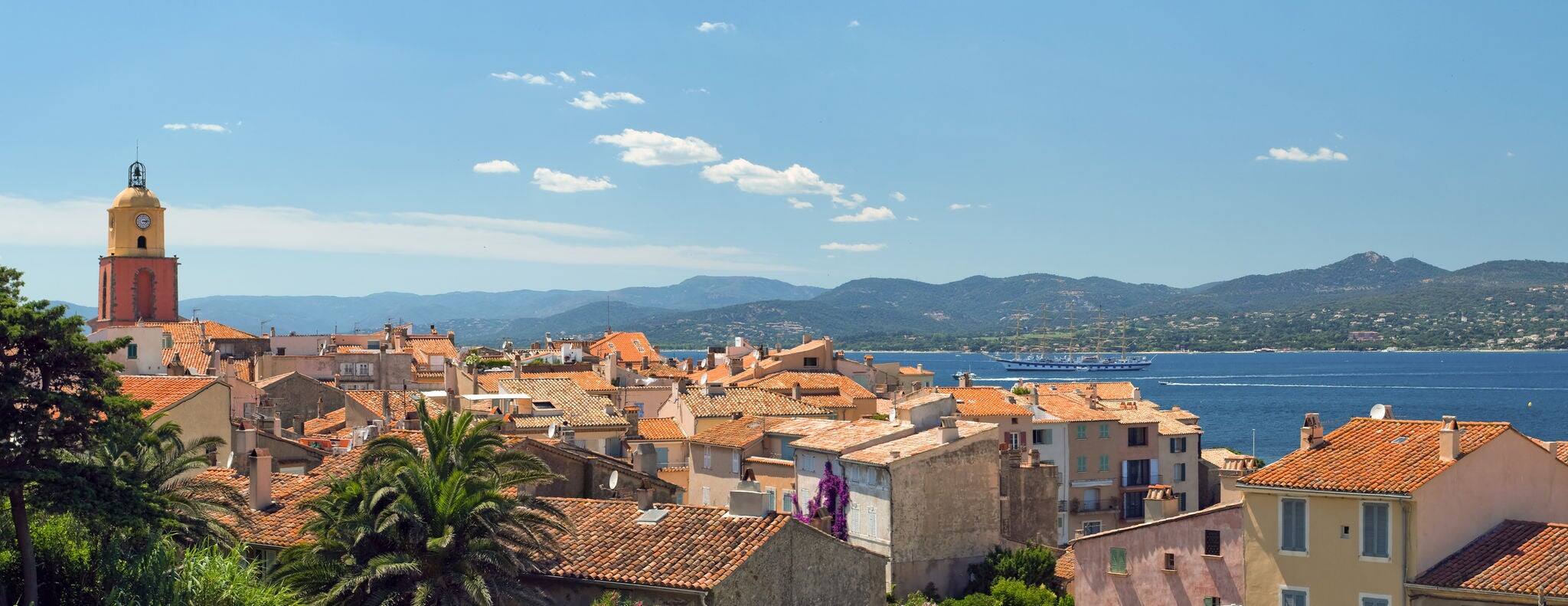 Image made with a sublime place of St Tropez, where the red roofs of the houses and the azure shore away from the horizon of the mountains.