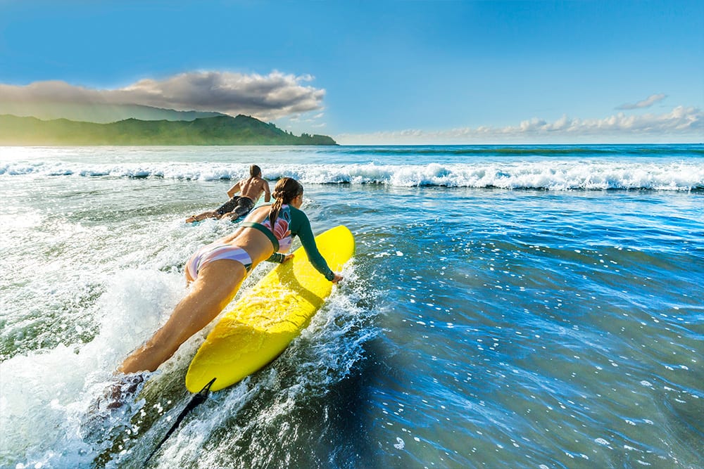 Couple surfing in Hanalei Bay, Hawaii
