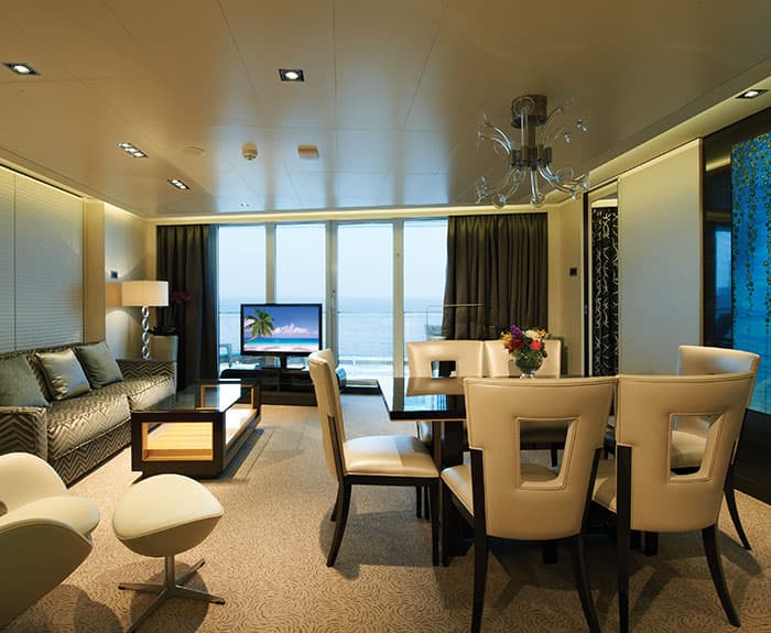 Sala de estar de The Haven's Deluxe Owners Suite con balcón grande en el Norwegian Getaway