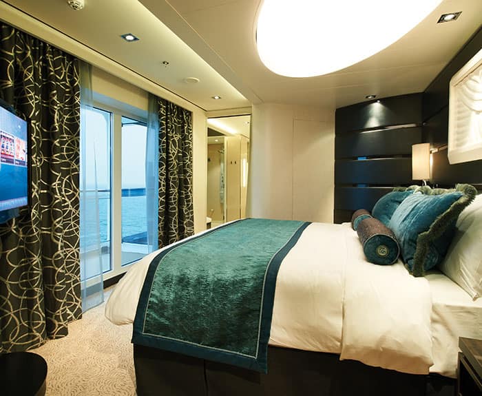 Habitación de The Haven's Deluxe Owners Suite con balcón grande en el Norwegian Getaway