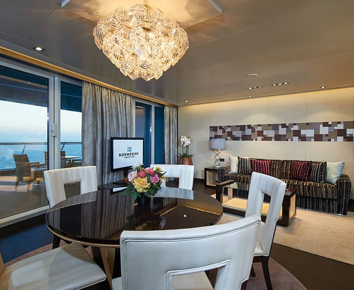 Sala de estar de The Haven's Deluxe Owners Suite con balcón grande en el Norwegian Escape