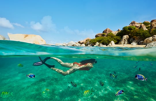 Muchacha buceando bajo el agua en una de las hermosas islas del Caribe durante su crucero