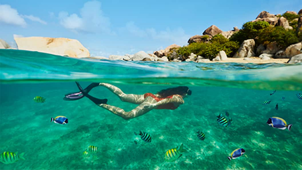 Muchacha buceando bajo el agua en una de las hermosas islas del Caribe durante su crucero